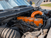 VC200 orange valve covers installed in a 12V Cummins engine bay with a matching orange intercooler pipe
