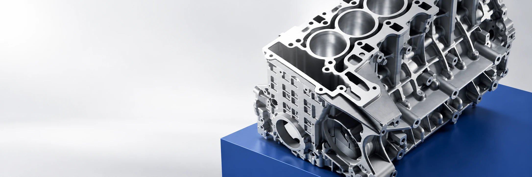 Studio concept of a machined engine block on a cobalt blue plinth