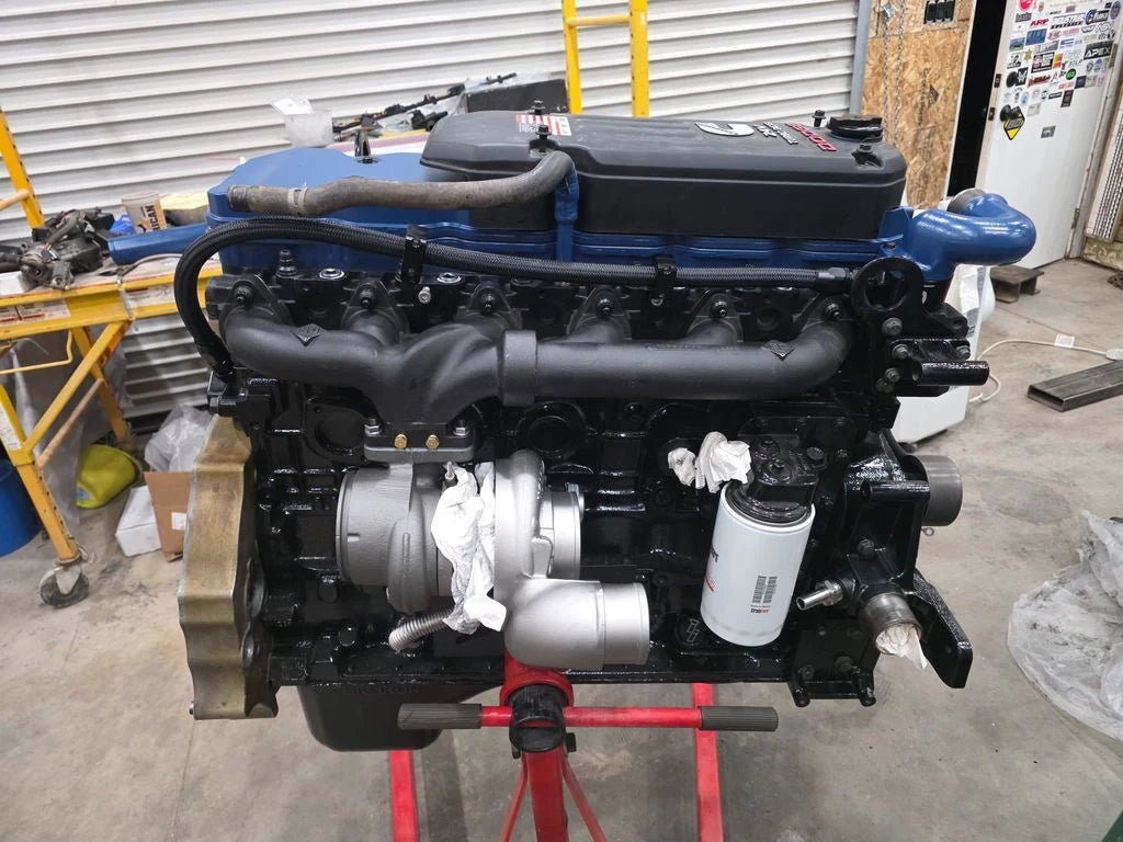 Blue and black Cummins engine on a red engine stand in Michael Hirschi’s workshop